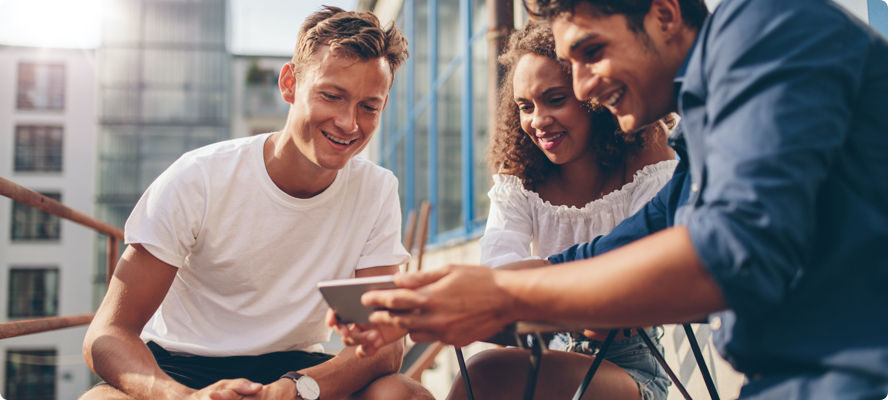 Three people looking at a smartphone