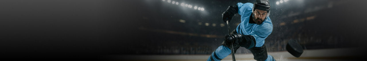 Action shot of a hockey player in a blue jersey.