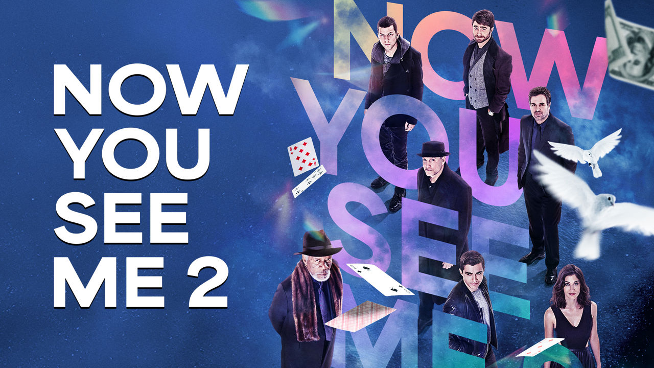 Now You See Me 2 movie poster featuring the main cast with magical elements like cards and doves against a blue starry sky.