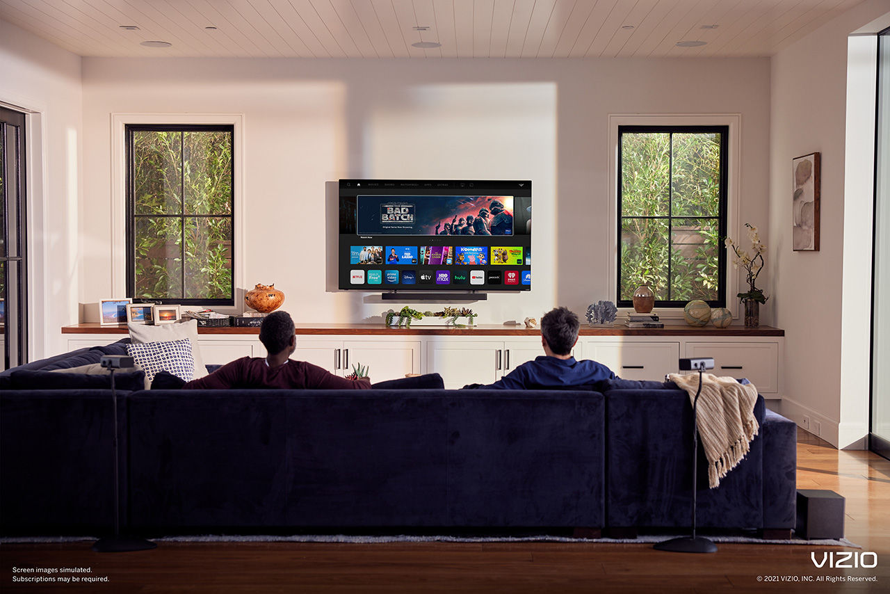 Two men sitting on couch watching Sling on a Vizio